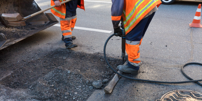 Photo of 2 workers performing road maintenance construction