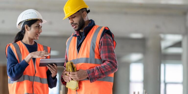 2 construction professionals looking at data on a tablet