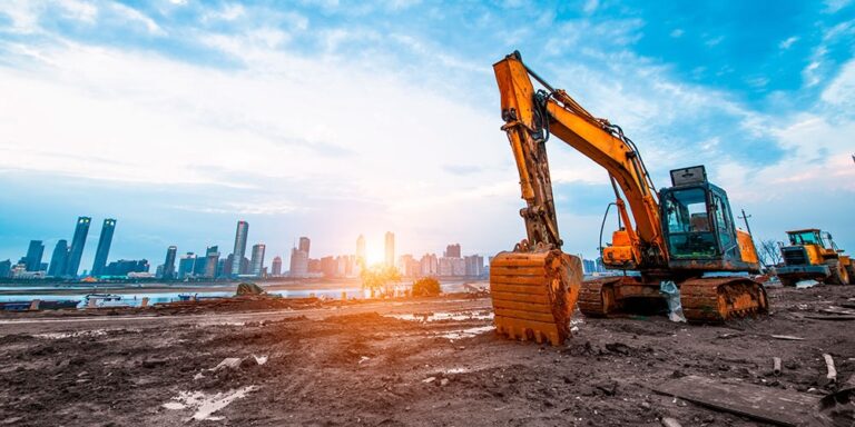 A civil construction project site with a city skyline in the background