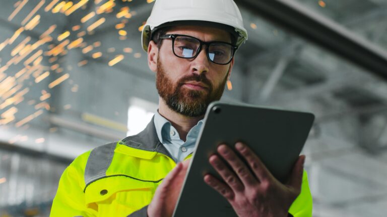 Worker on a jobsite using construction AI on a tablet