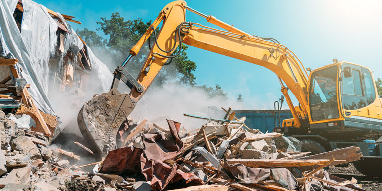 Backhoe demolishing a building