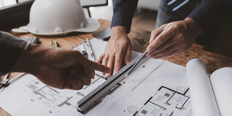 Two people working on construction drawings