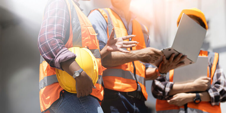 3 construction workers using tech — laptops, tablets, and phones