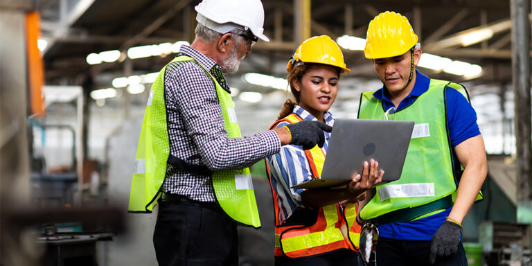 3 construction professionals gathered around a laptop