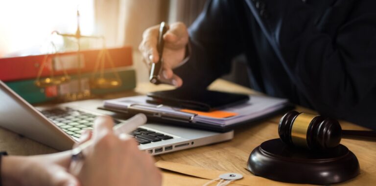 Client talks to lawyer and looks at documents on the lawyer's desk.