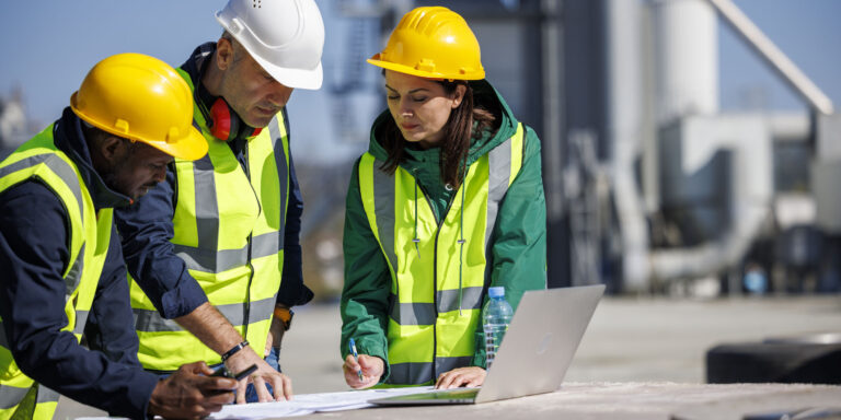 Construction professionals discussing variation orders at an industrial facility.