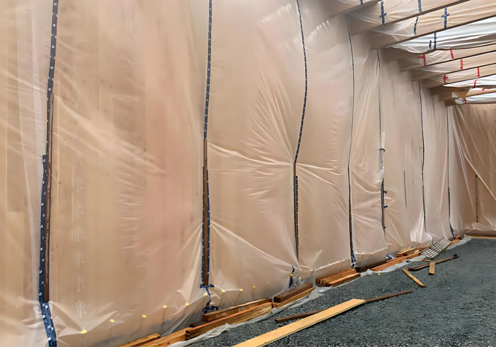 Photo of plastic wrapped wooden walls for a gymnasium project being put in place.