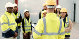 Mental health toolbox talk with several workers listening in a circle