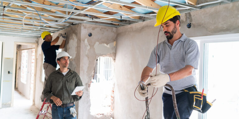 Utility workers installing electrical in an unfinished building