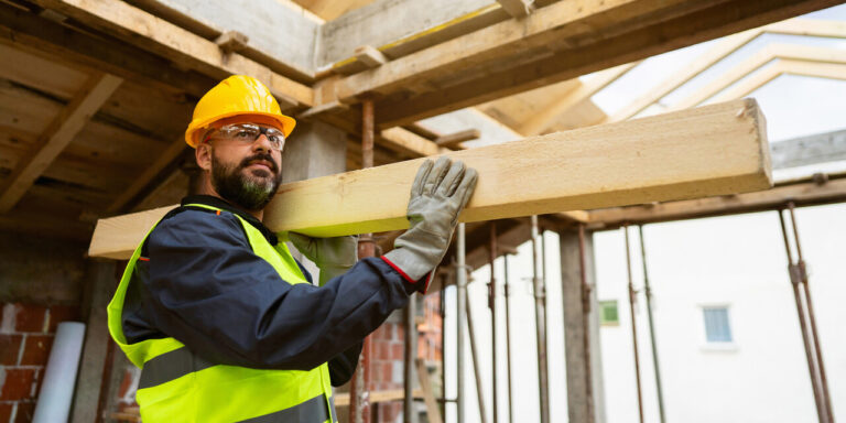 Construction worker moving lumber