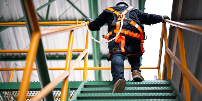 Construction worker in safety PPE ascending a staircase