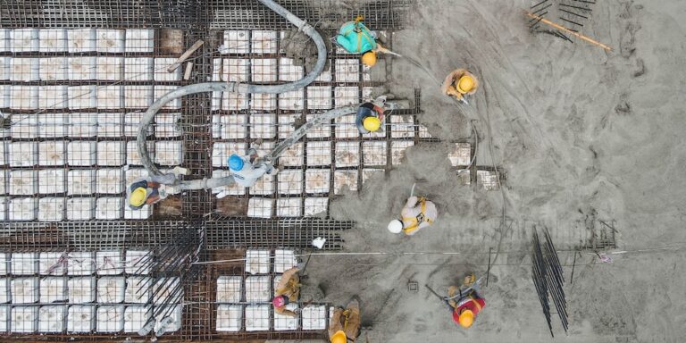 Overhead view of construction workers laying a concrete pad