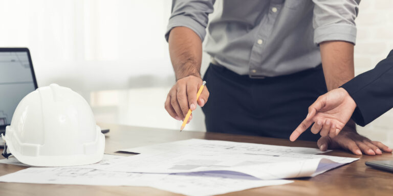 Construction professionals looking at proposal documents on a table